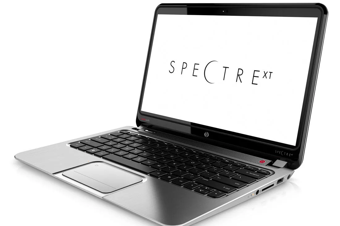 Open HP Spectre XT laptop with silver body and black keyboard; screen shows the word SPECTRE XT.