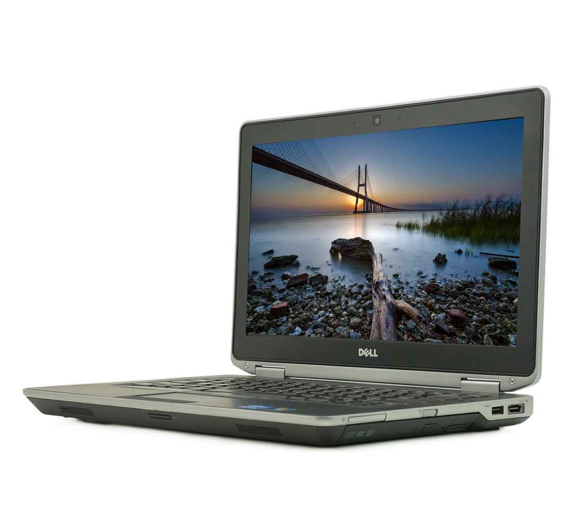 Dell laptop open with a sunset bridge wallpaper on the screen, placed on a white background.