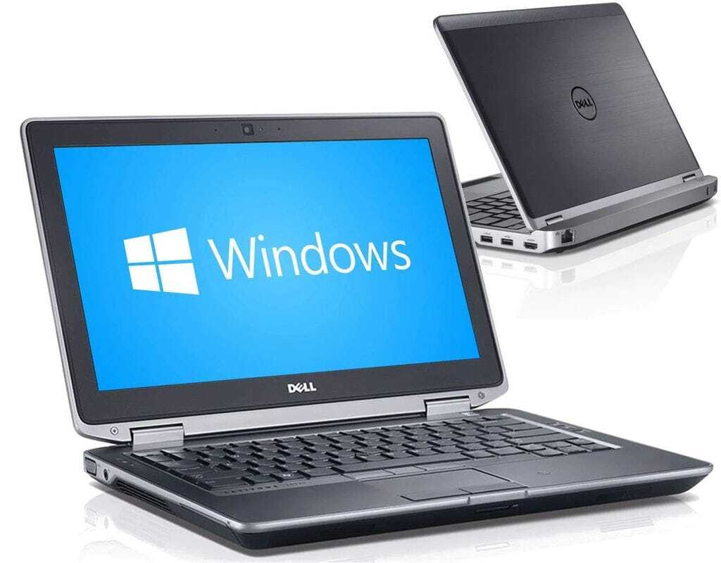 Two Dell laptops, one open with a Windows blue screen and logo, another closed in the background on a white surface.