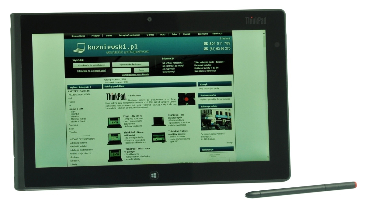 Tablet computer displaying kuzniowski.pl homepage on screen; a stylus rests to the right on a white background.