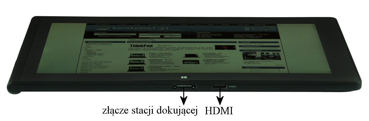 Tablet laid flat showing side ports: docking station connector and an HDMI port, with a ThinkPad web page visible on the screen