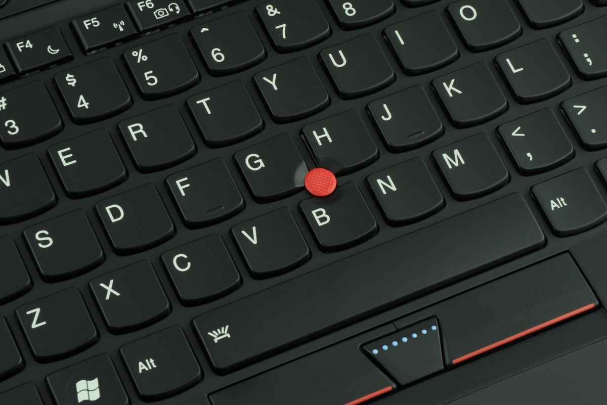 lenovo-thinkpad-x1-carbo_118388 - lab-kuzniewski.pl - Testy laptopów, recenzje i porównania Close-up of a black laptop keyboard with a red TrackPoint nub in the center of the keys.