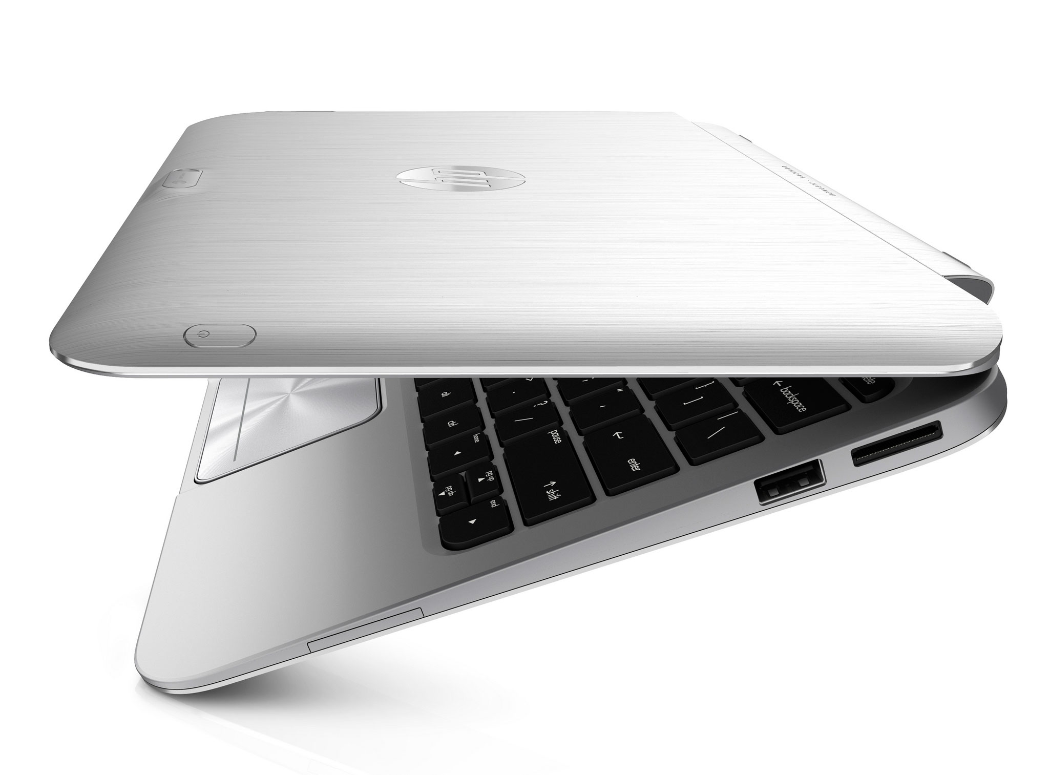 Angled close-up of a closed silver HP laptop with a brushed metal lid and visible keyboard edge