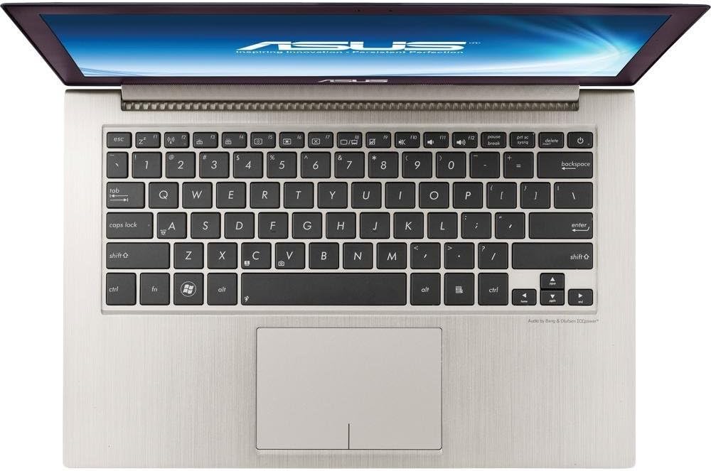 Top-down view of a silver laptop open, showing a black keyboard and large touchpad.