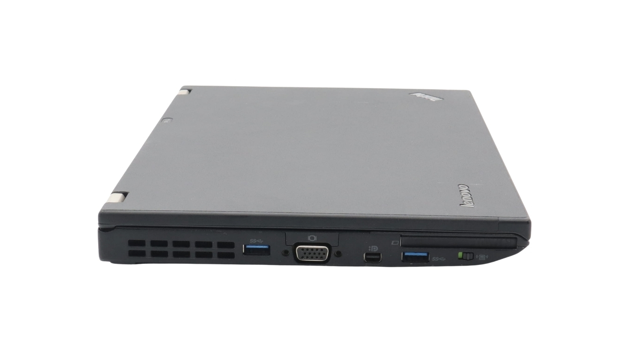 Lenovo ThinkPad X230i_0906_03 - lab-kuzniewski.pl - Testy laptopów, recenzje i porównania Side view of a closed Lenovo laptop showing multiple ports along the front edge (USB, VGA, HDMI, card reader) and the Lenovo logo visible on the lid.