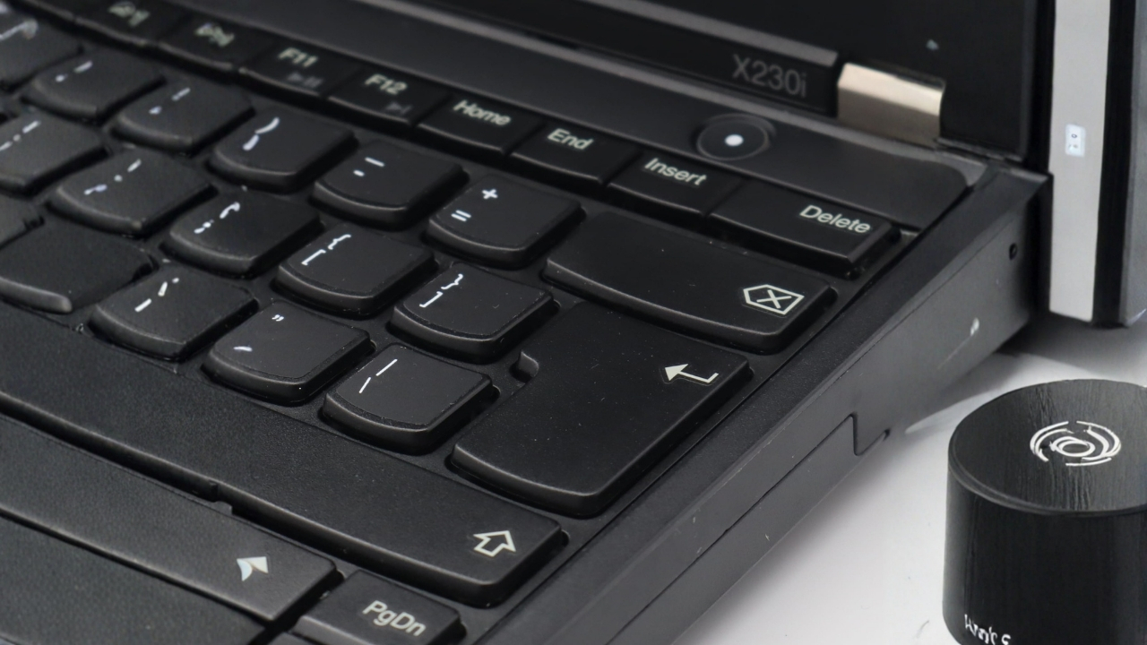 Lenovo ThinkPad X230i_0906_05 - lab-kuzniewski.pl - Testy laptopów, recenzje i porównania Close-up of a black laptop keyboard showing arrow keys and a circular control knob on the right side.