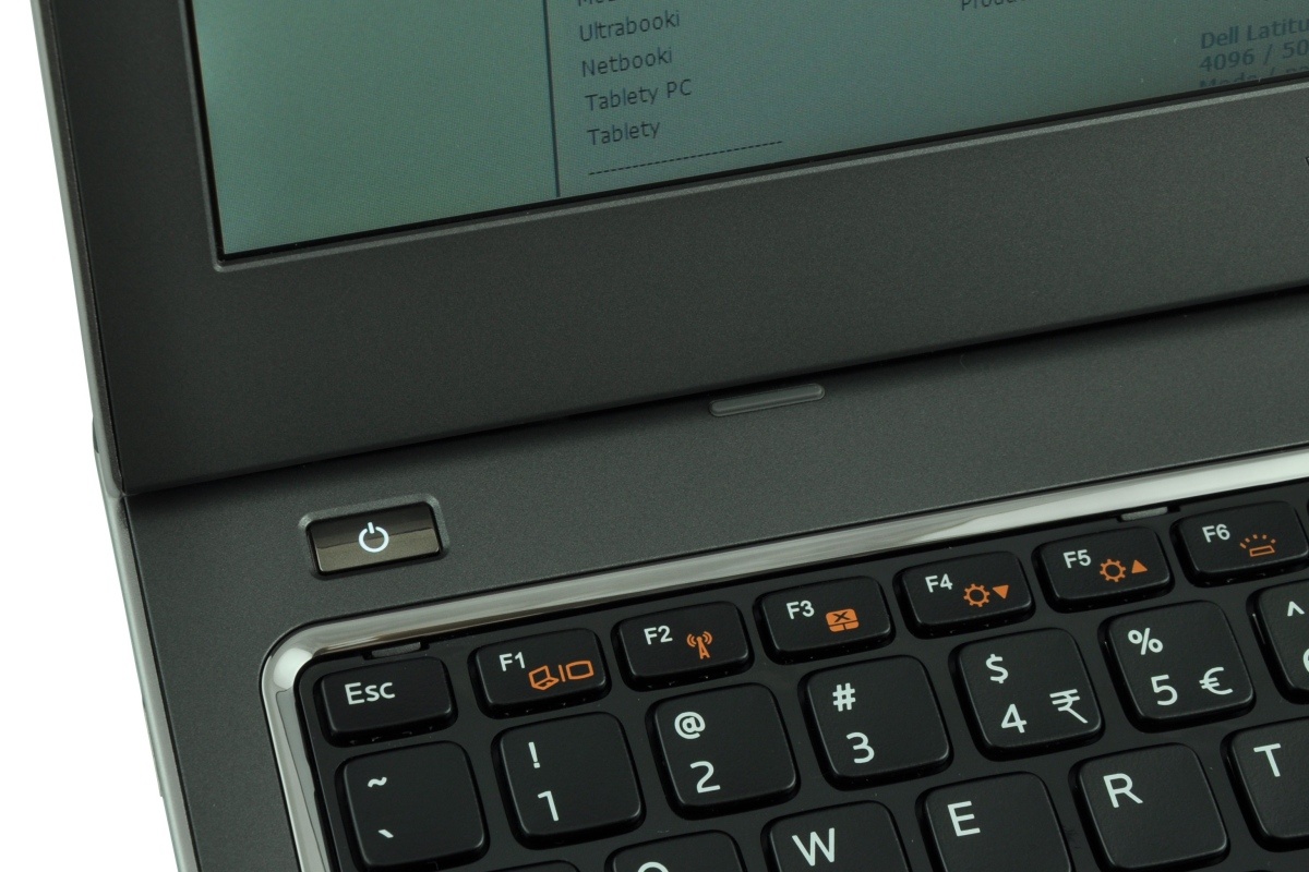 Close-up of a laptop keyboard and power button on the left, showing F1–F6 keys and orange indicator icons.