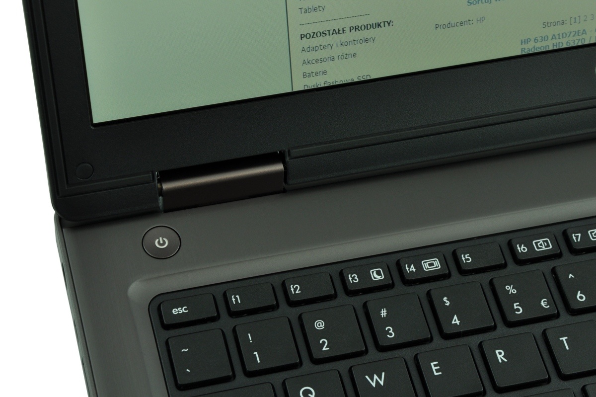 Close-up of a laptop keyboard and lower screen edge, showing the power button and hinge area
