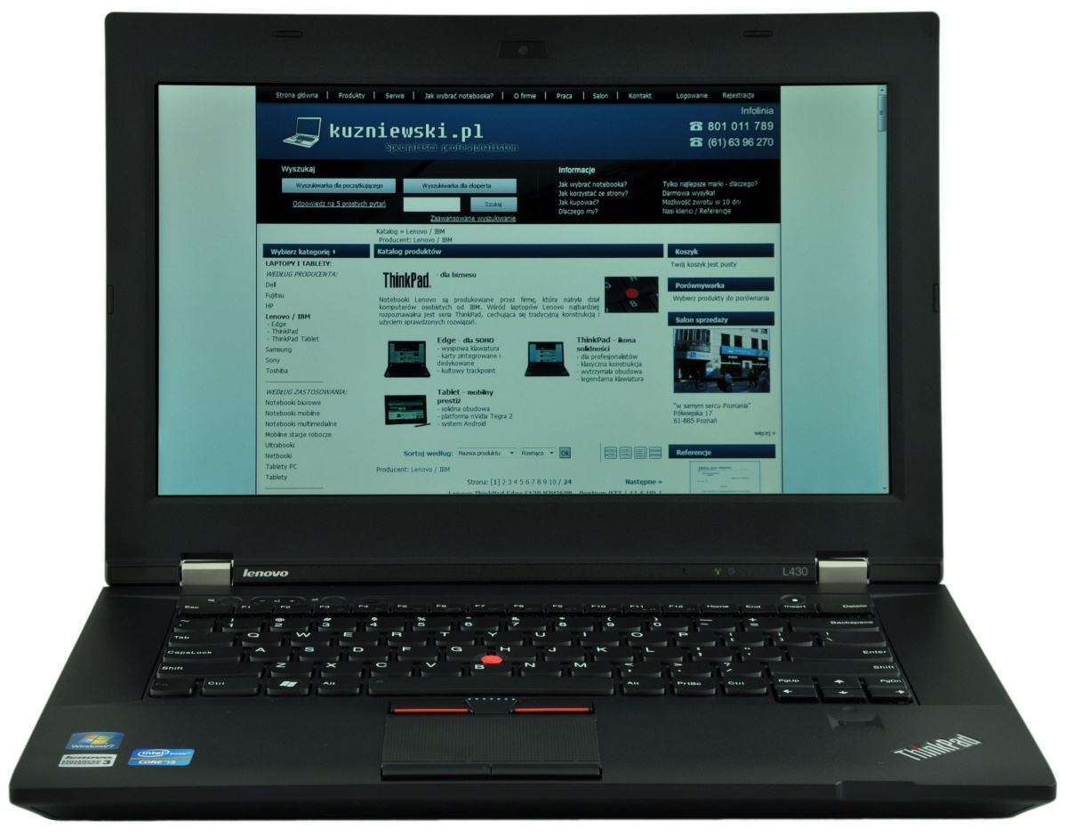 Black Lenovo ThinkPad laptop open, displaying a blue Polish tech website on its screen, keyboard visible in the foreground.