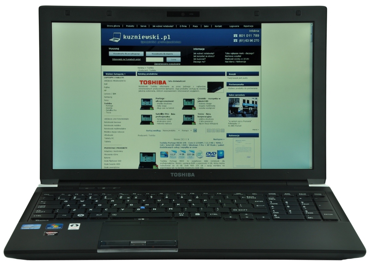 Open Toshiba laptop displaying a tech website homepage with a blue header on screen.