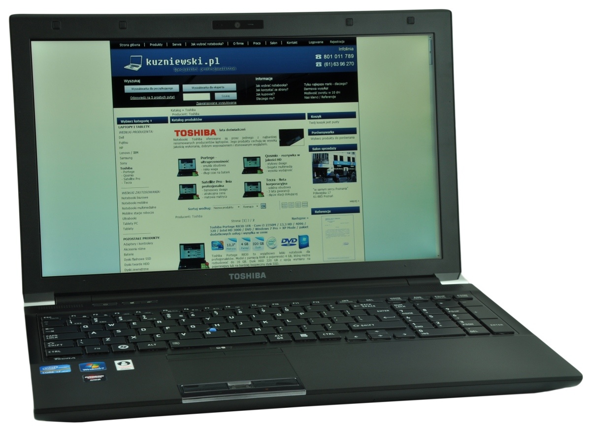 Toshiba laptop open with a blue-header website loaded on the screen, showing product listings.