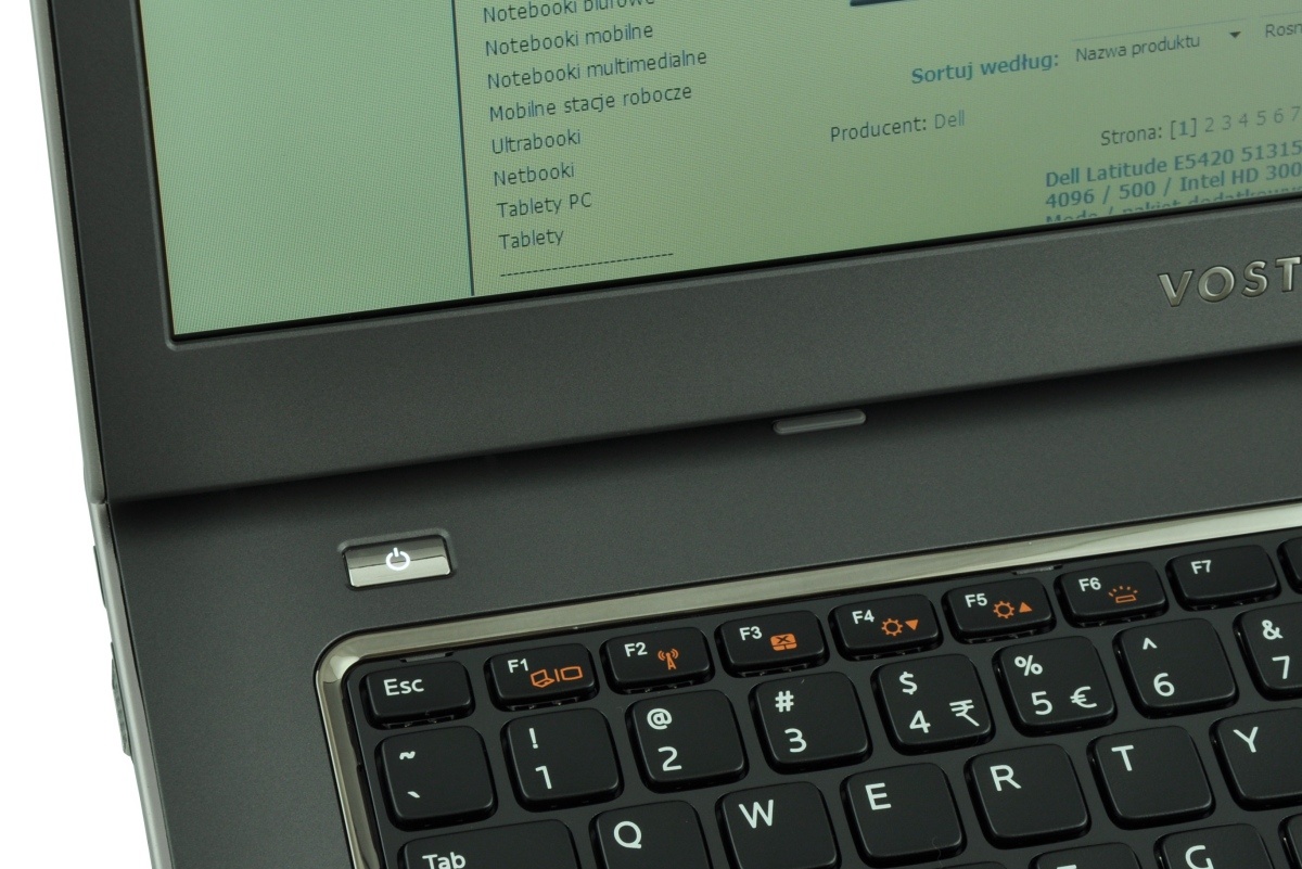 dell-vostro-3560-5160973_122377 - lab-kuzniewski.pl - Testy laptopów, recenzje i porównania Close-up of a Dell Vostro laptop keyboard with a power button and a green screen above the keyboard edge.