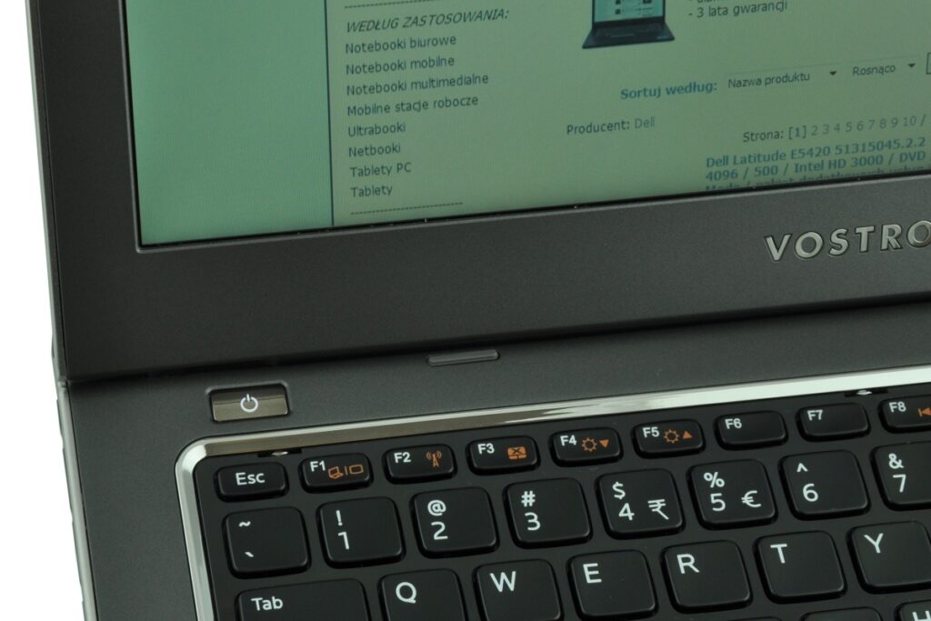 Close-up of a Dell Vostro laptop showing the keyboard and lower bezel with the power button visible and a partial screen above.