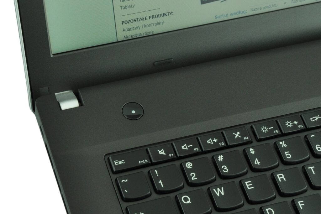 lenovo-thinkpad-edge-e43_122484 - lab-kuzniewski.pl - Testy laptopów, recenzje i porównania Close-up of a black laptop keyboard; round power button with a blue LED near the hinge, screen shows a Polish webpage.