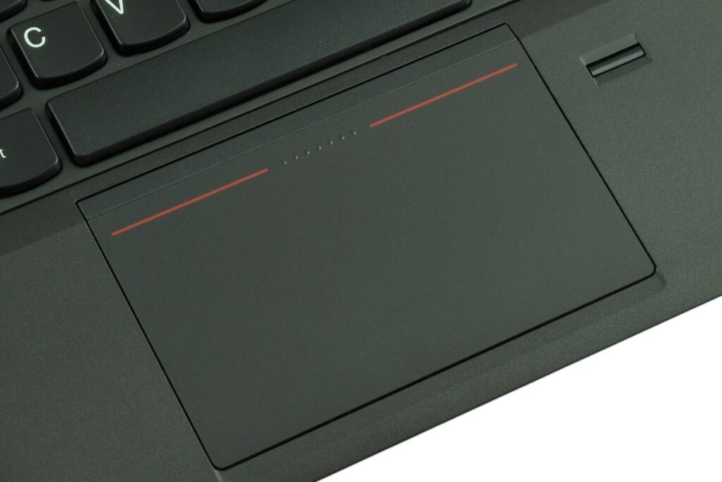 lenovo-thinkpad-edge-e43_122485 - lab-kuzniewski.pl - Testy laptopów, recenzje i porównania Close-up of a black laptop touchpad with red accent lines.