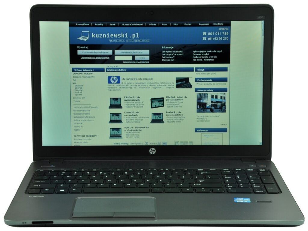 HP laptop open and displaying a blue e-commerce site (kuzniewski.pl) with product catalog and navigation on the screen.