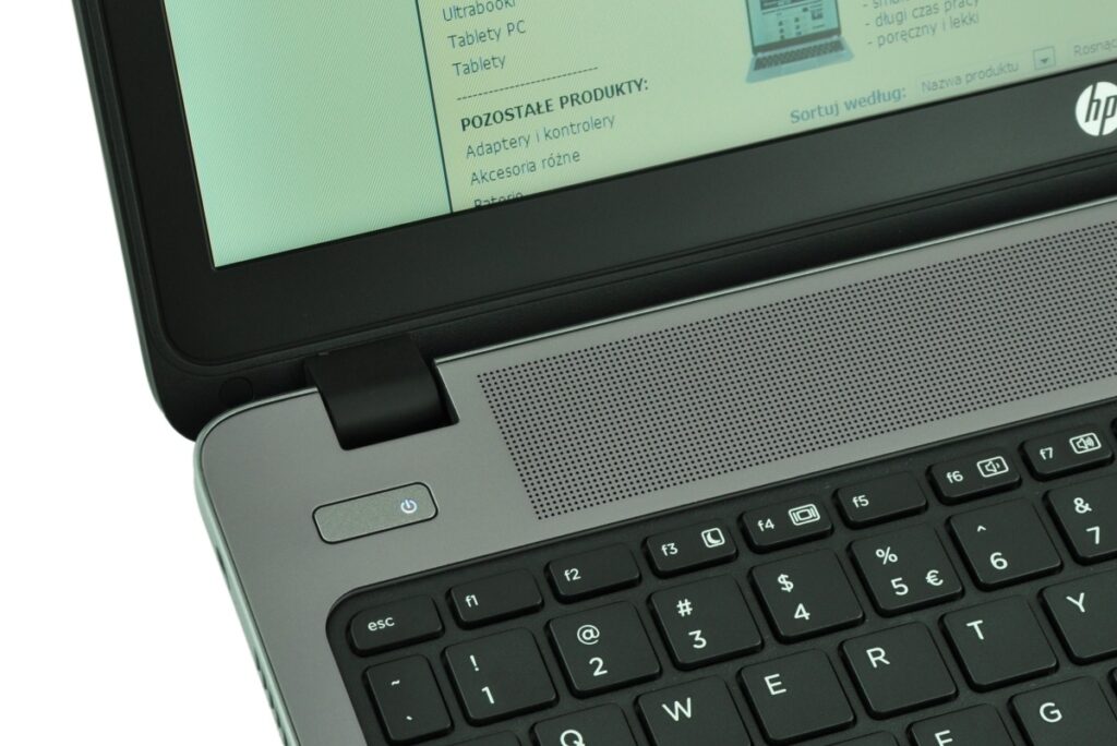 hp-probook-450-g0-h0u97e_126304 - lab-kuzniewski.pl - Testy laptopów, recenzje i porównania Close-up of a laptop with a speaker grille, power button, and screen showing Polish text; HP logo visible on the side.