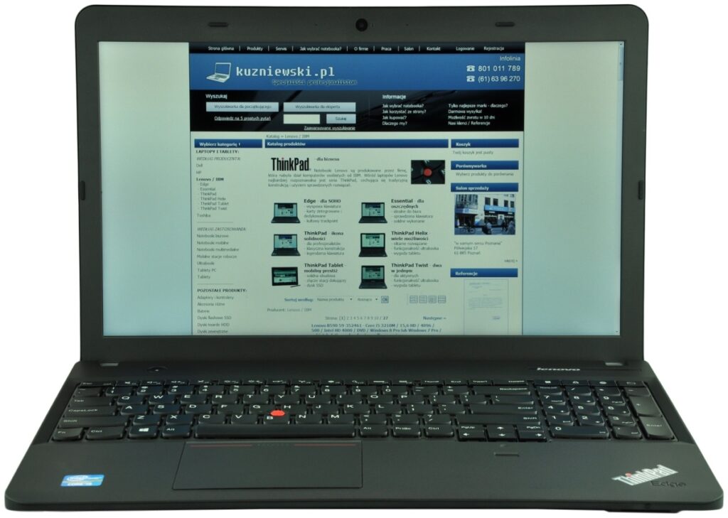 Black Lenovo ThinkPad laptop open, displaying a blue Polish website on the screen; keyboard features a red TrackPoint.