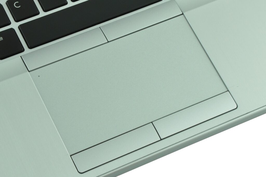 Close-up of a silver laptop showing a large touchpad with two slim buttons beneath it and a portion of the keyboard above.