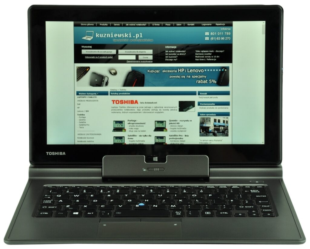 Toshiba laptop open, displaying a website layout with blue header and product ads on the screen.
