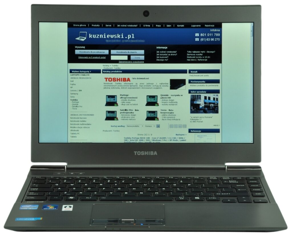 Toshiba laptop open to a Polish electronics website with product grid on the screen.