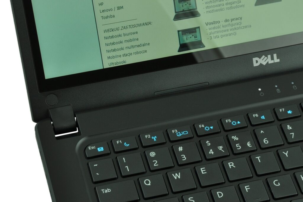 Close-up of a Dell laptop keyboard and screen, with a green-tinted display showing a Polish product page.",