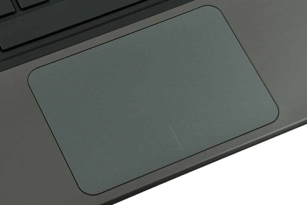 Close-up of a gray laptop touchpad with rounded corners on the palm rest area.