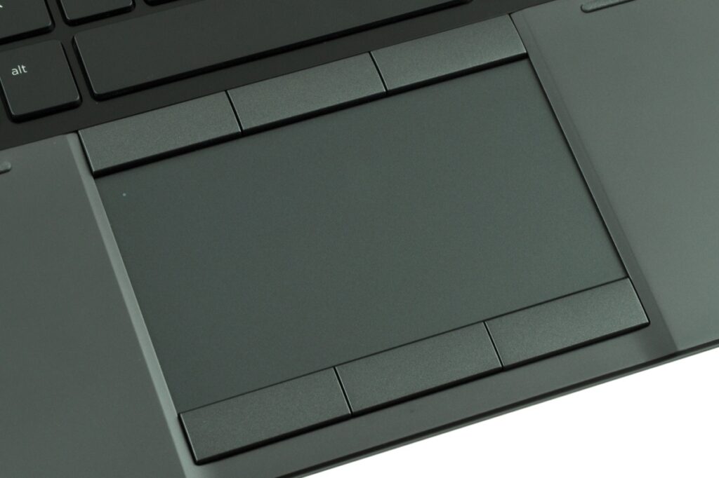 Close-up of a dark gray laptop touchpad surrounded by its palm-rest area and narrow click buttons above and below.