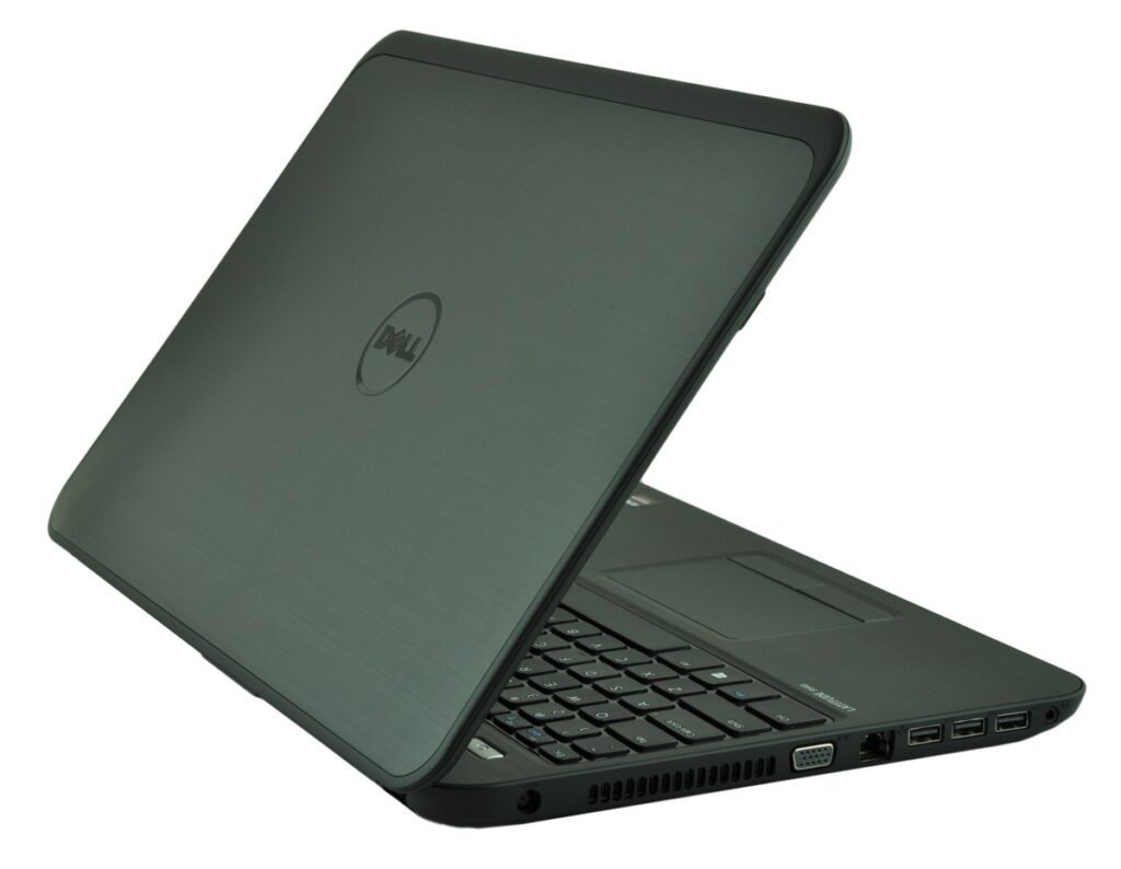 Open Dell laptop in a dark gray finish showing keyboard and port side from a diagonal angle