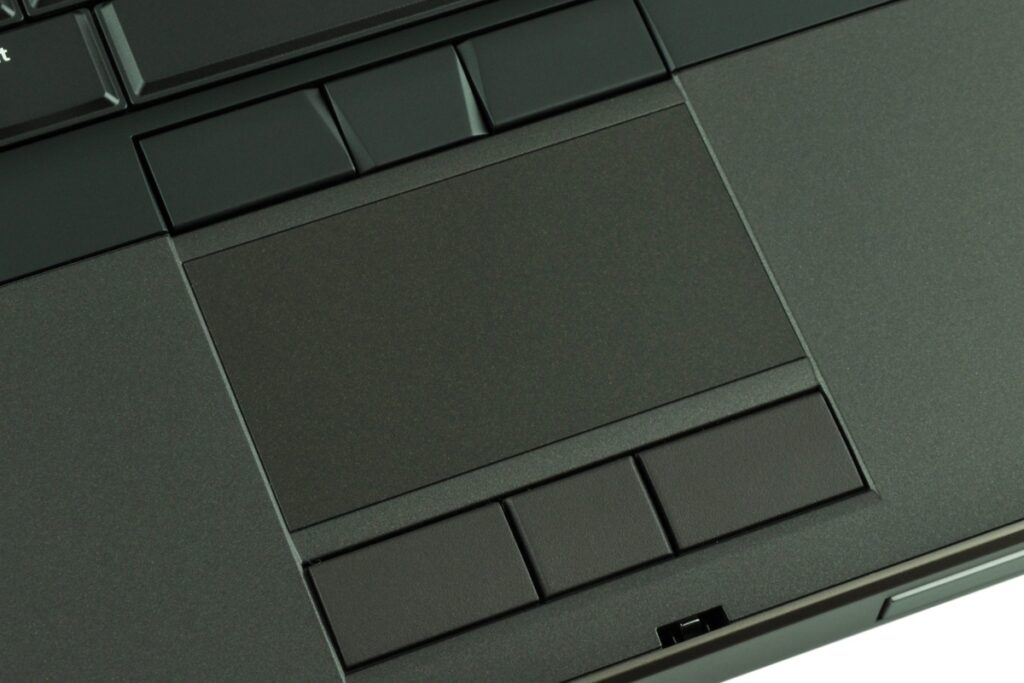 dell-precision-m4800-516_125165 - lab-kuzniewski.pl - Testy laptopów, recenzje i porównania Close-up of a dark laptop touchpad with surrounding keys and buttons