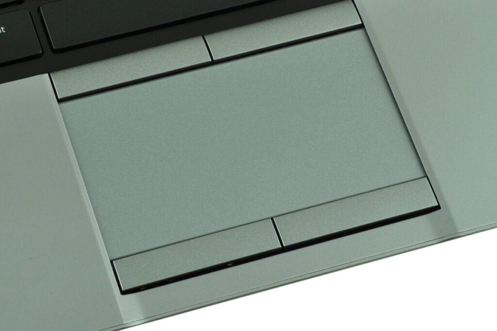 Close-up of a silver laptop touchpad area with left/right buttons and surrounding palm rest, viewed from above