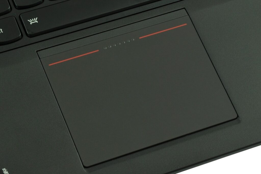 Close-up of a dark laptop touchpad with red accent lines, keyboard edge visible above.