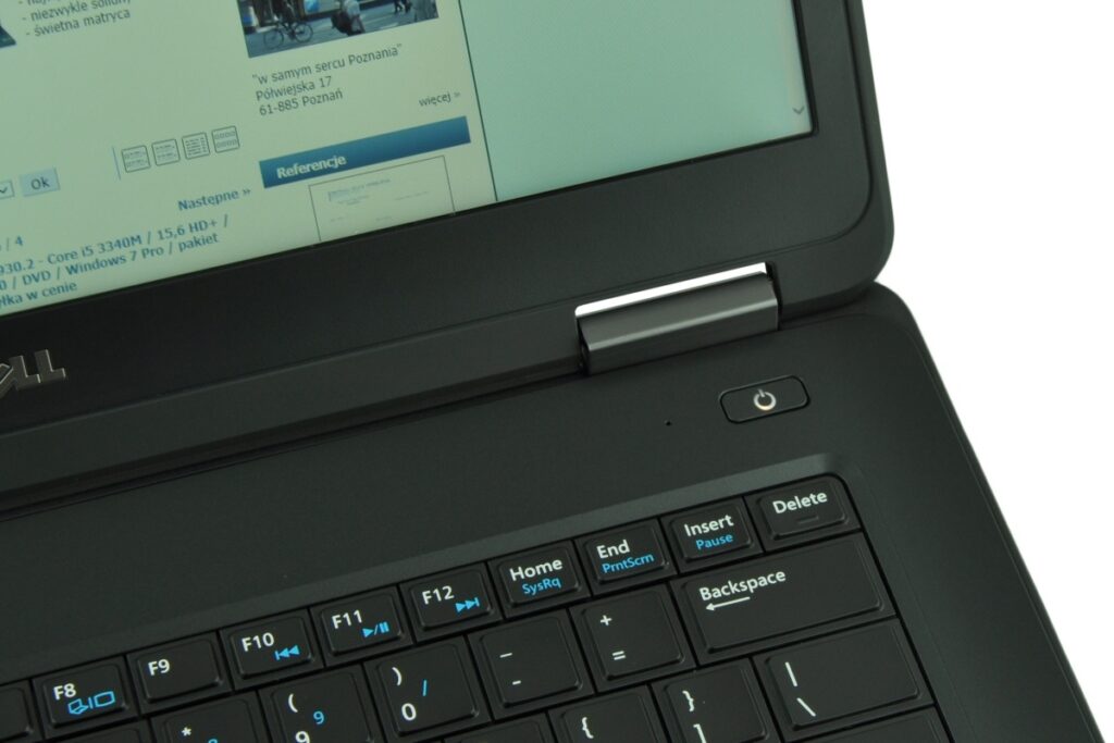 dell-latitude-e5440-5194_125290 - lab-kuzniewski.pl - Testy laptopów, recenzje i porównania Close-up of a Dell laptop keyboard and power button, with the screen showing a webpage in Polish.