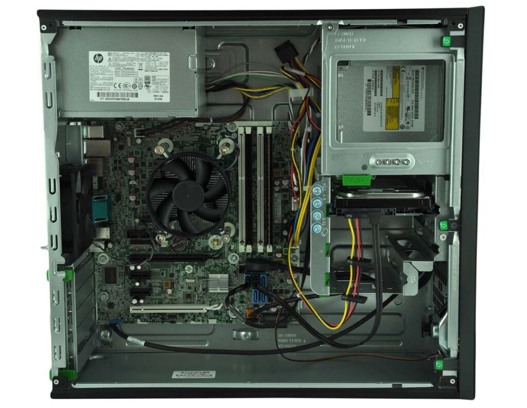 Interior view of a desktop computer case showing the motherboard, CPU cooler fan, RAM, power supply at top-left, expansion slots, drive bays, and tangled cables with side panel removed.