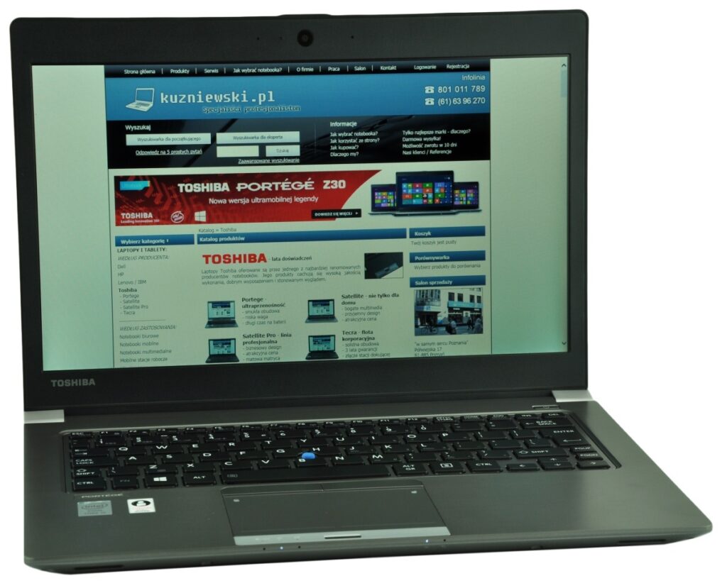 Toshiba laptop open, displaying a Polish technology website on the screen.