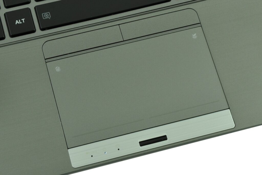 Close-up of a gray laptop palm rest showing a large touchpad; the keyboard edge with an ALT key is visible in the top-left corner.