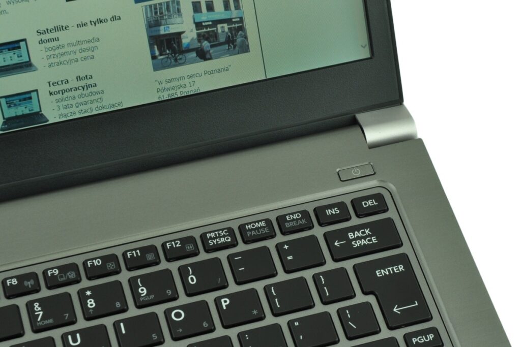 Close-up of a silver laptop keyboard with a browser page visible on the screen.