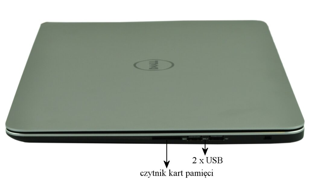 Closed silver Dell laptop viewed from the side, showing two USB ports and a memory card reader on the edge.