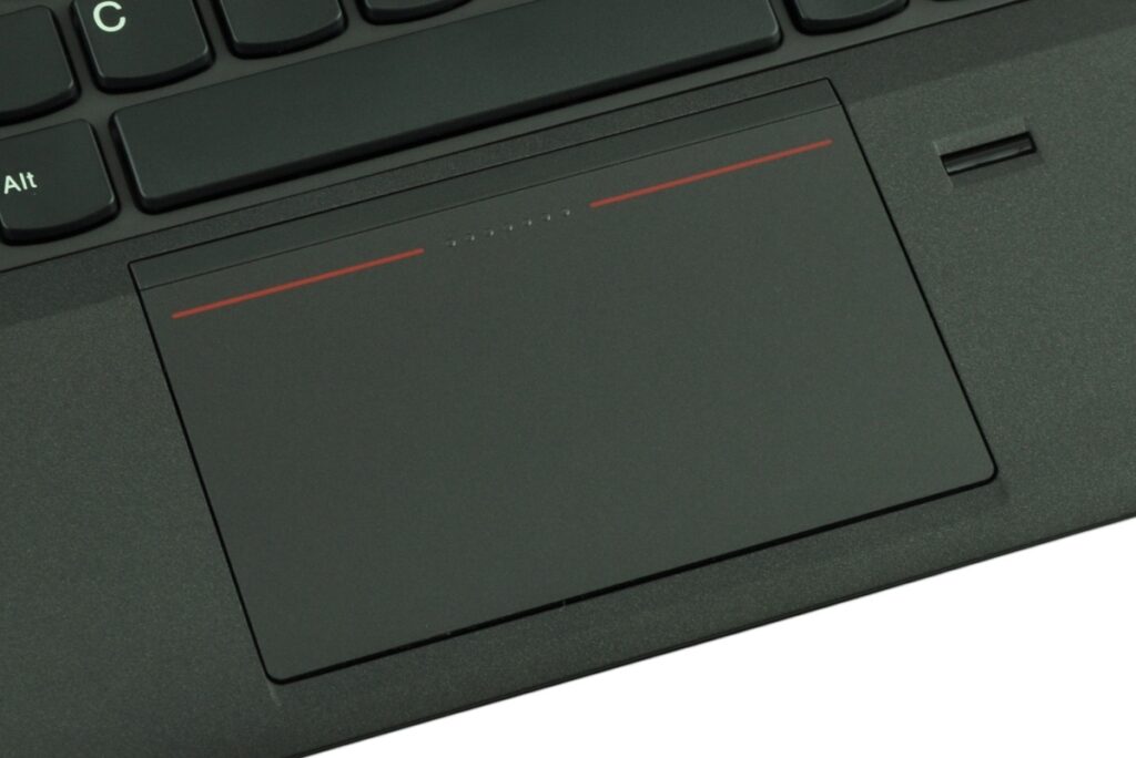 Close-up of a black laptop touchpad on a keyboard, with a thin red line at the top edge.