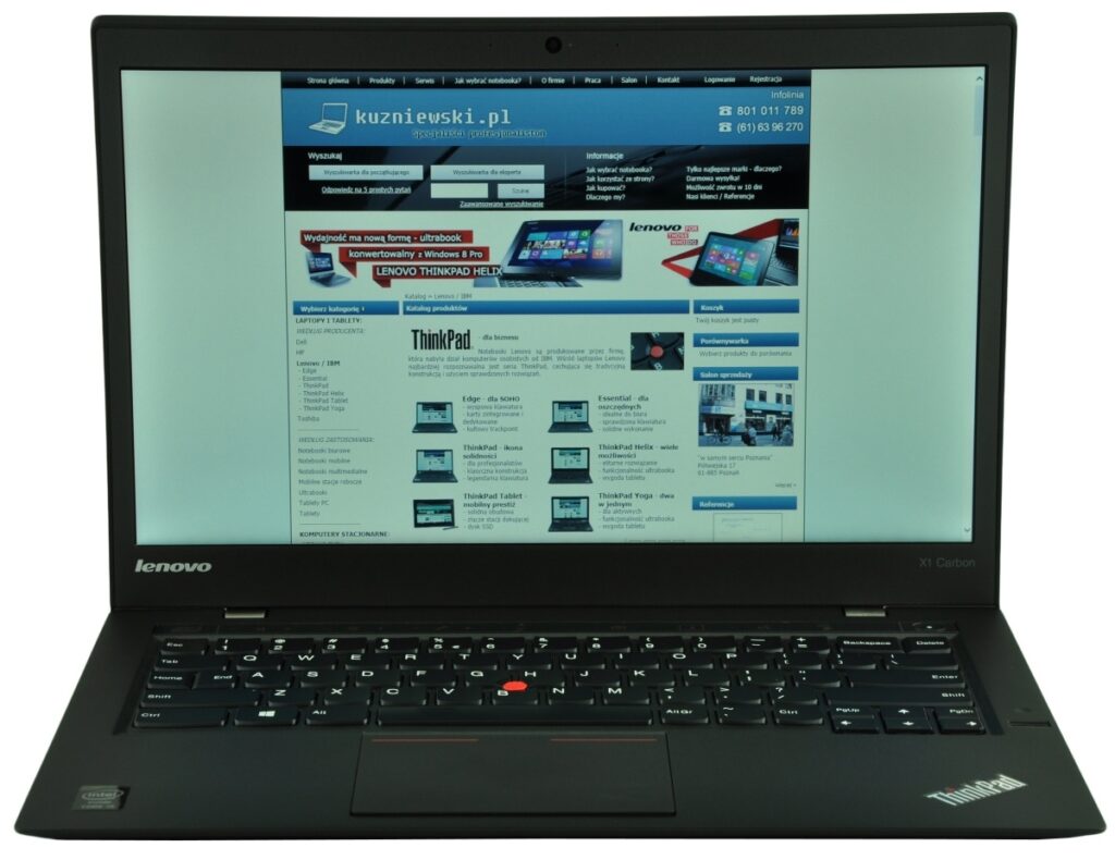 lenovo-thinkpad-new-x1-c_125567 - lab-kuzniewski.pl - Testy laptopów, recenzje i porównania Open black Lenovo ThinkPad laptop displaying a blue business website on the screen, keyboard visible with a red TrackPoint in the middle and ThinkPad logo on the palmrest.