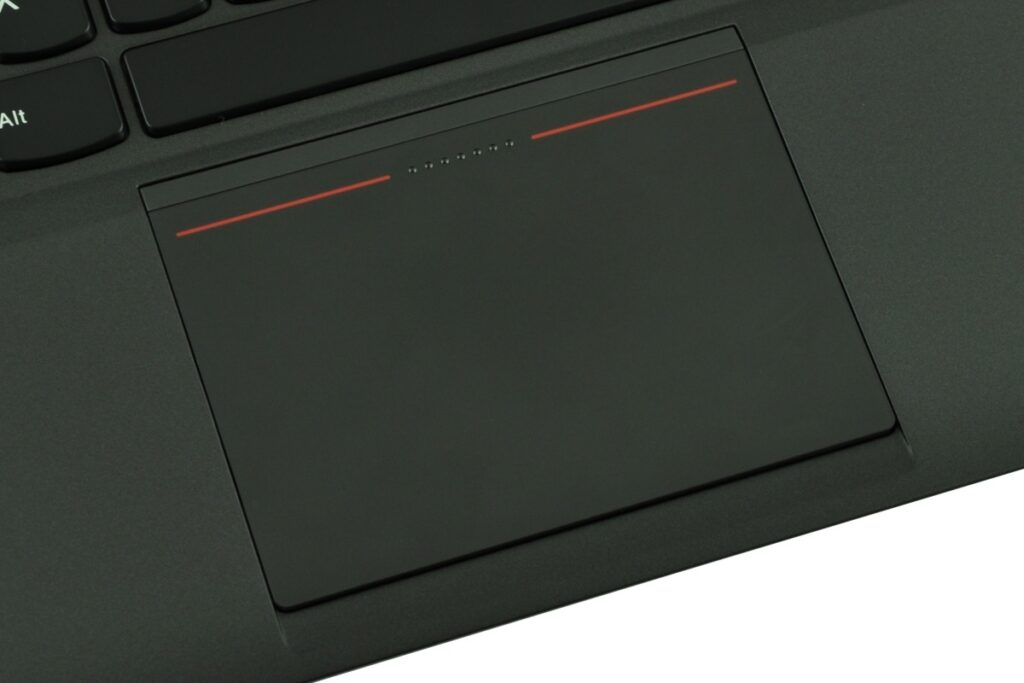lenovo-thinkpad-new-x1-c_125572 - lab-kuzniewski.pl - Testy laptopów, recenzje i porównania Close-up of a black laptop touchpad on a keyboard, showing the large rectangular input surface and surrounding palm rest edge.