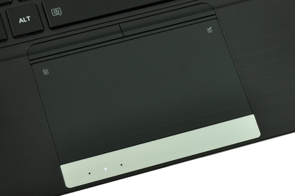 Close-up of a black laptop touchpad with left/right click areas and a metal horizontal palm-rest trim.