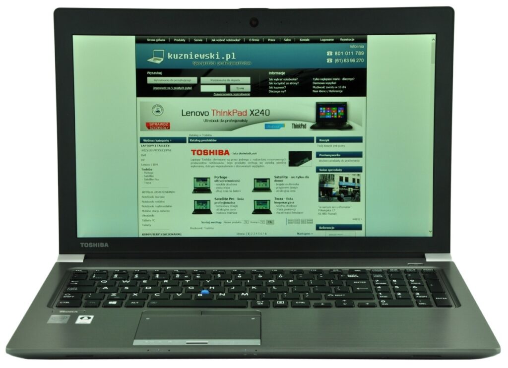 Toshiba laptop open with a website displayed on the screen, showing a Polish online store layout.
