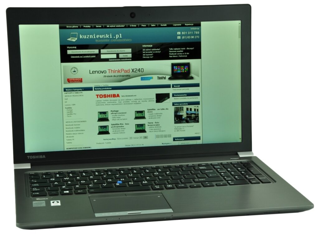 Toshiba laptop with a web browser displaying a Polish e-commerce homepage on the screen.