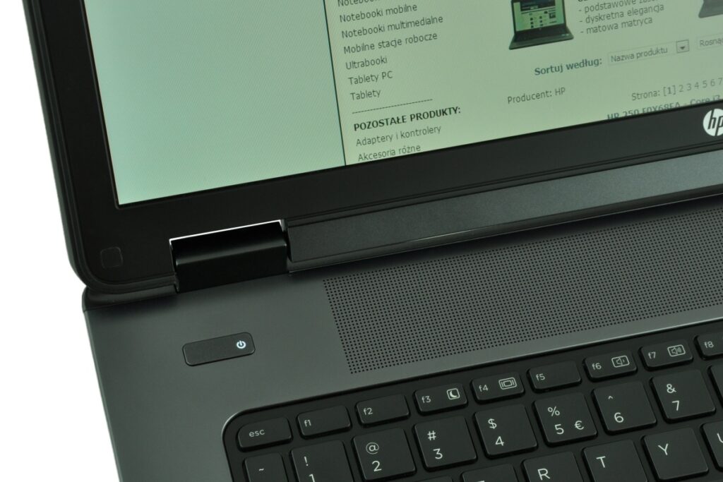 hp-zbook-17-g1-f0v51ea-c_126983 - lab-kuzniewski.pl - Testy laptopów, recenzje i porównania Close-up of an HP laptop opened, showing the power button, speaker grill, and keyboard with a web page on the screen in Polish