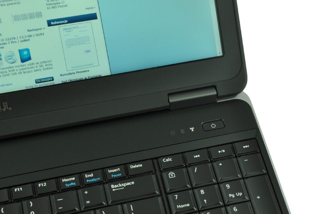 Close-up of a black Dell laptop showing a blue-tinted screen and a keyboard in the foreground.