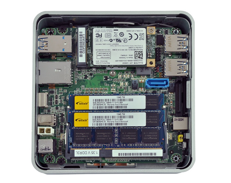 Inside view of a compact mini PC motherboard with RAM sticks and a Wi‑Fi card