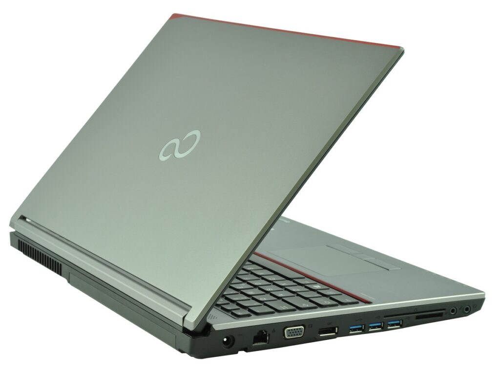 Open silver laptop slightly angled, red trim, showing side ports (VGA, USB, Ethernet, audio).