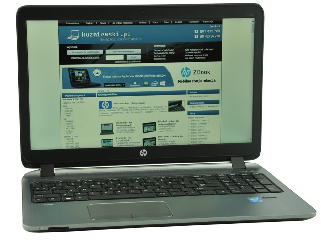 HP laptop showing a Polish website on its screen, blue header and navigation visible