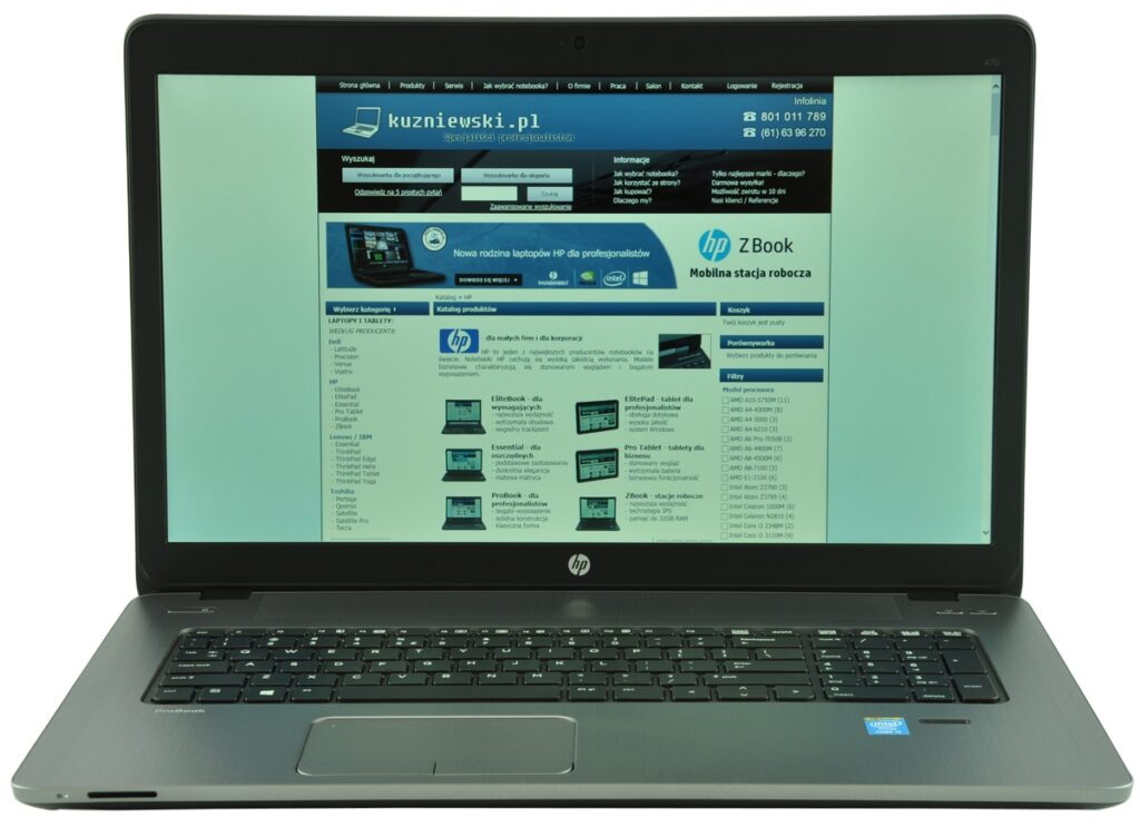 HP laptop open to a website homepage displayed on the screen, keyboard visible on a silver-gray chassis in a bright setting